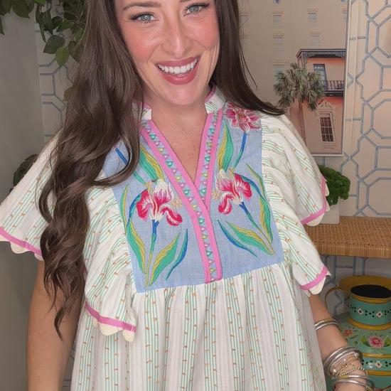 Woman wearing a colorful embroidered blouse in an indoor setting