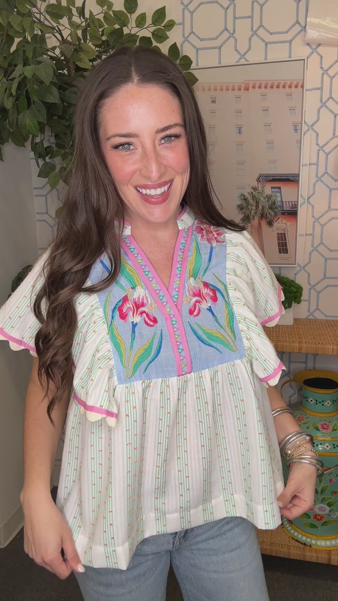 Woman wearing a colorful embroidered blouse in an indoor setting