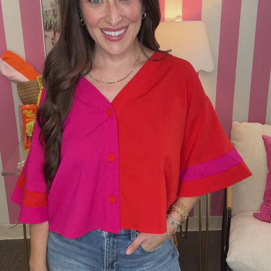 Woman wearing a colorful blouse with a striped wall in the background