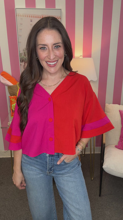 Woman wearing a colorful blouse with a striped wall in the background