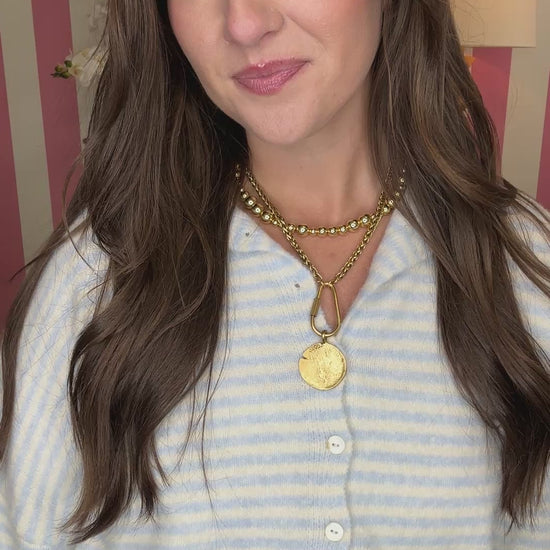 Woman wearing a white top and floral skirt with lemon pattern in a room with striped walls.